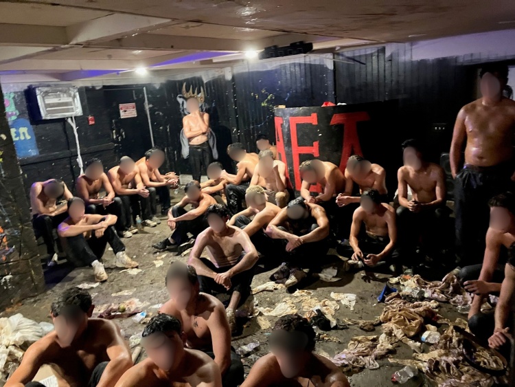 The identifies of the pledges involved in a hazing incident are concealed in an image showing them gathered in a basement.